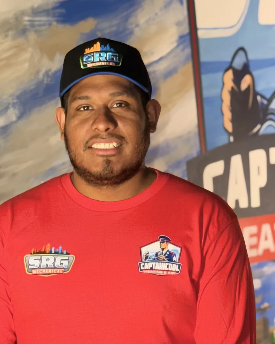 Smiling Captain Cool Heating & Air team member in a cap and red company shirt