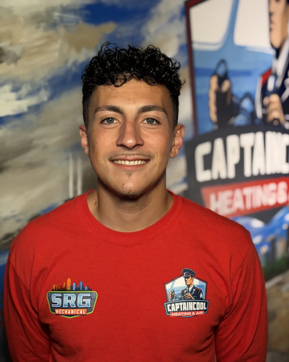 Smiling Captain Cool Heating & Air team member with curly hair in a red company shirt