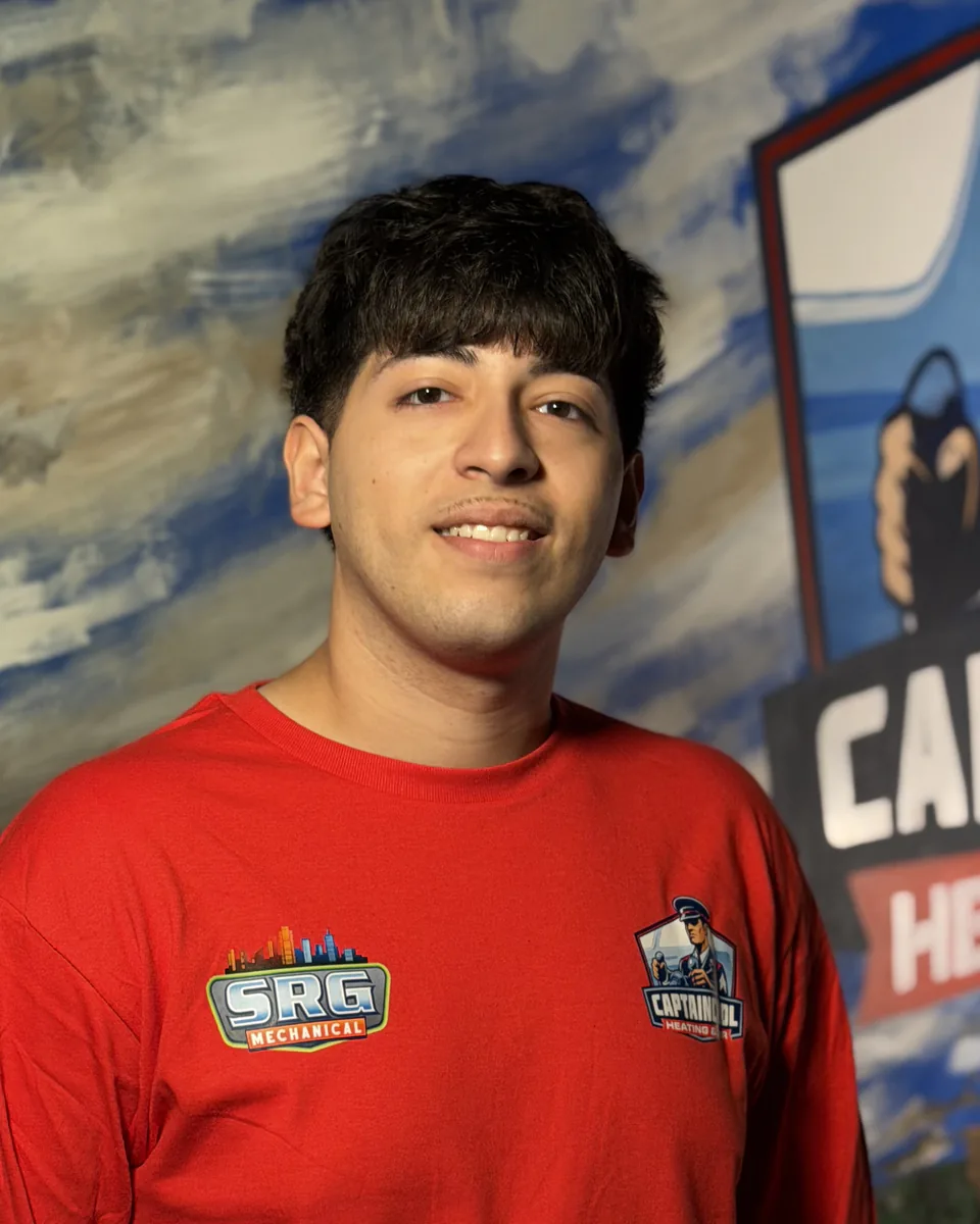 Captain Cool Heating & Air team member in a red company shirt in front of the captain mural